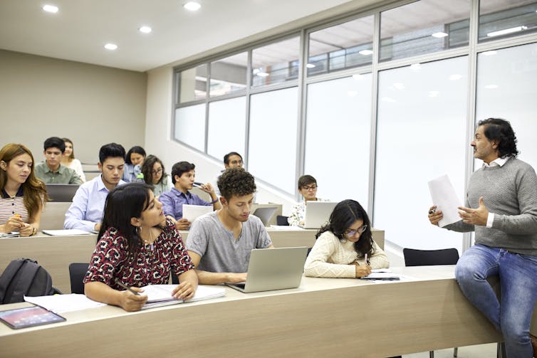 A college instructor leads a discussion in a lecture hall.