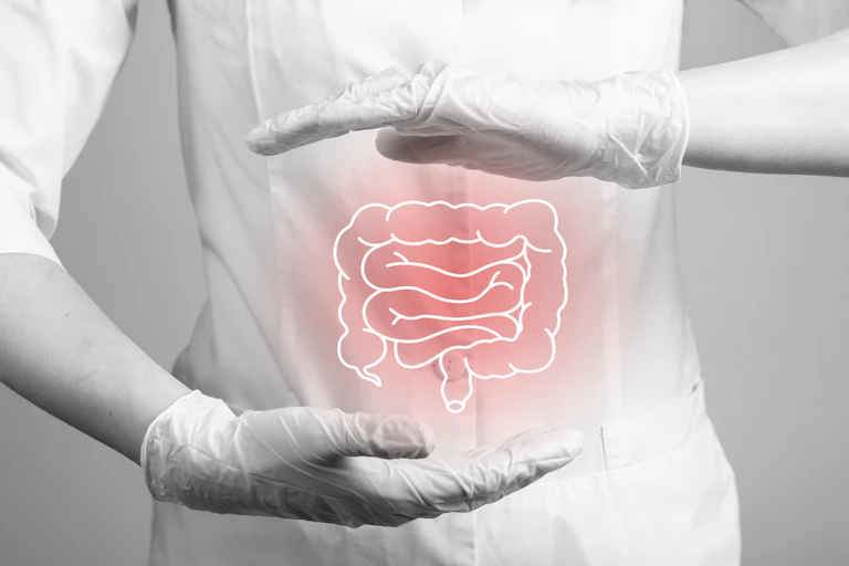 Person wearing white uniform and white gloves framing an illustrated white outline of a colon glowing red