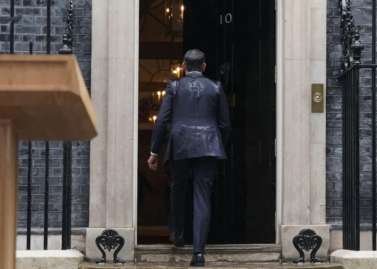 Rishi Sunak walking into Downing Street with a soaking wet back.