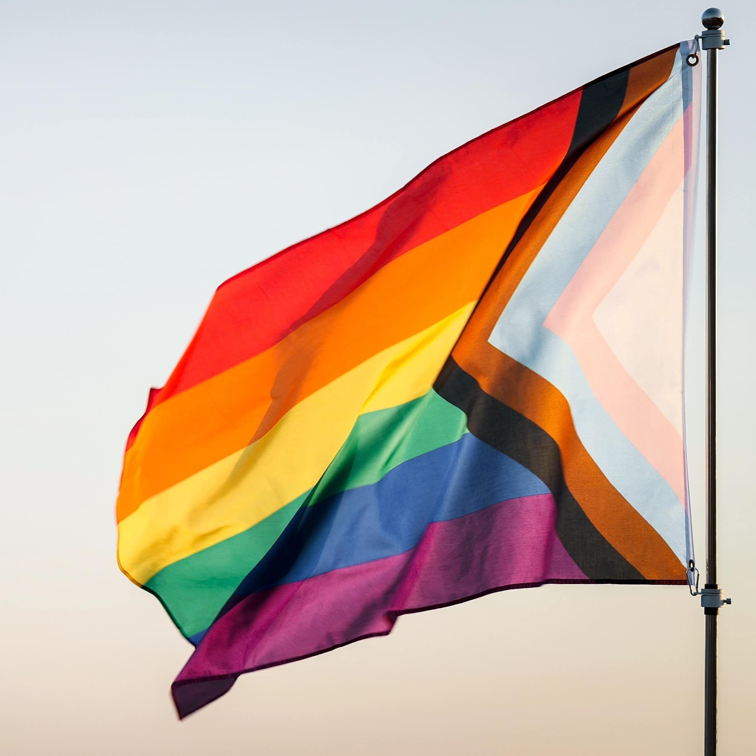A rainbow flag on a pole
