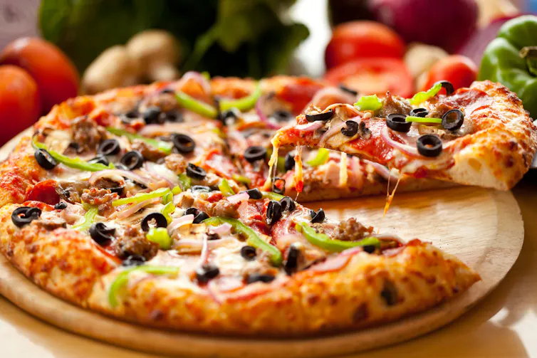 Someone lifting a slice of pizza