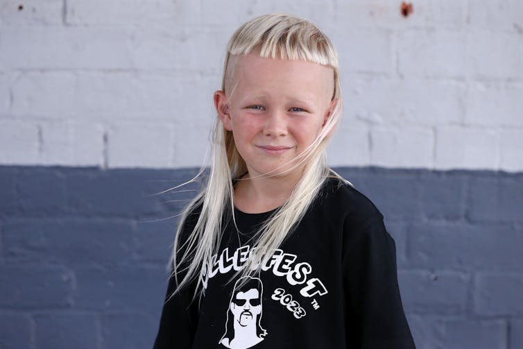 A young boy with a straight, white blond mullet.
