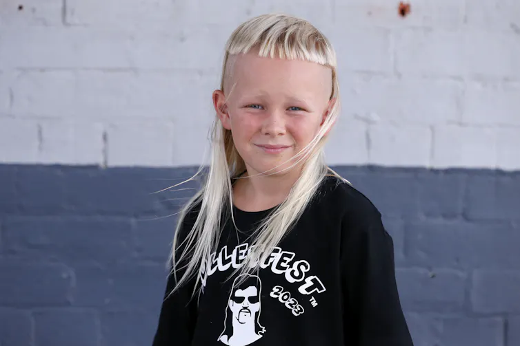A young boy with a straight, white blond mullet.