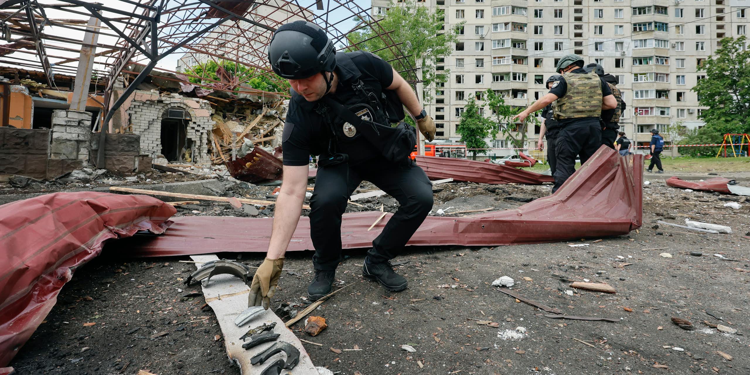 Ukrainian security forces examine the aftermath of a Russian airstrike in Kharkiv, northern Ukraine.