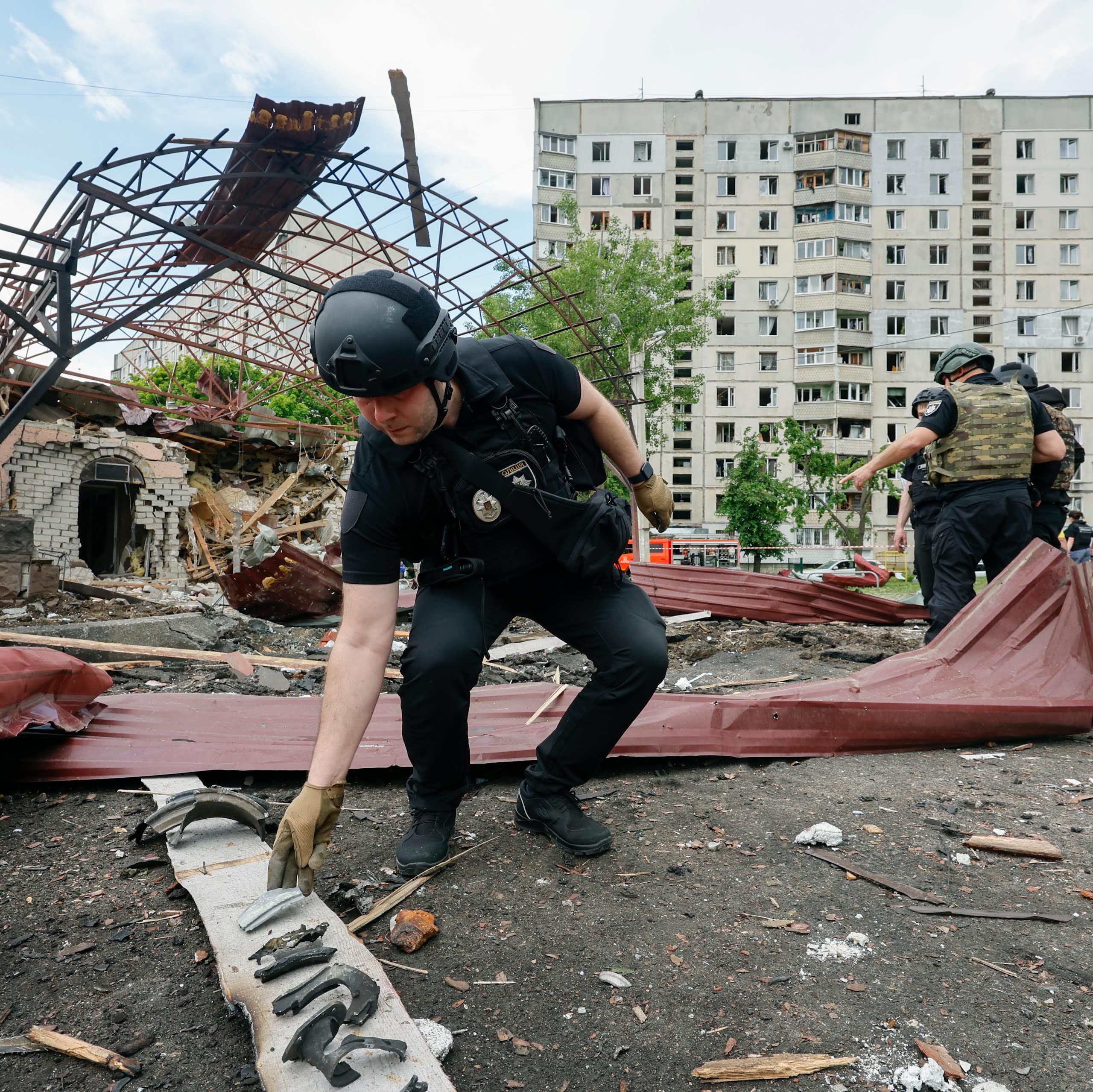 Ukrainian security forces examine the aftermath of a Russian airstrike in Kharkiv, northern Ukraine.