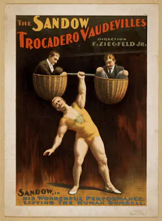 A poster for a strongman event showing a mostly naked man holding up two men in baskets with one hand.