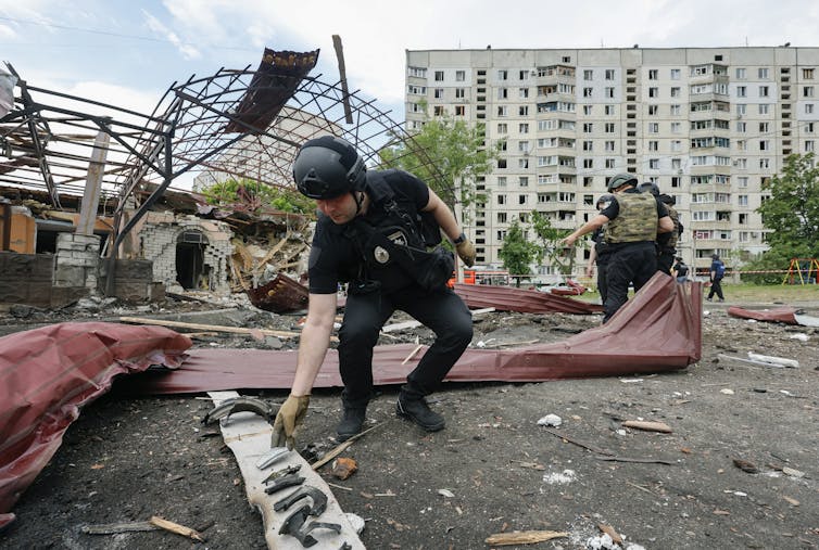 Ukrainian security forces examine the aftermath of a Russian airstrike in Kharkiv, northern Ukraine.