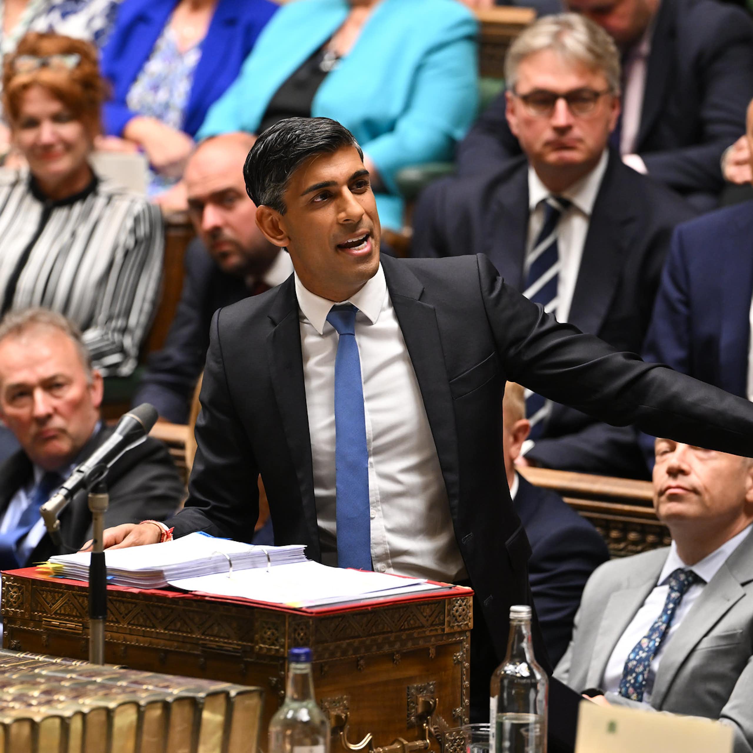 Rishi Sunak standing at the dispatch box and speaking in the house of commons, while pointing emphatically to his left