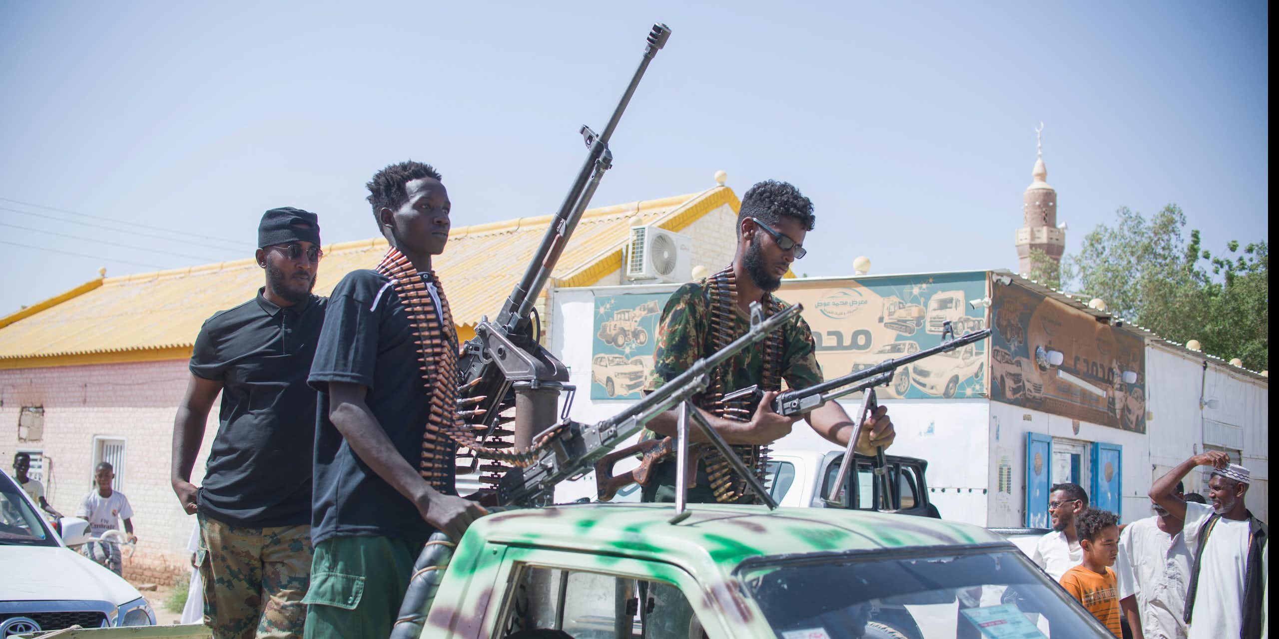 Men on the back of a truck with large guns.