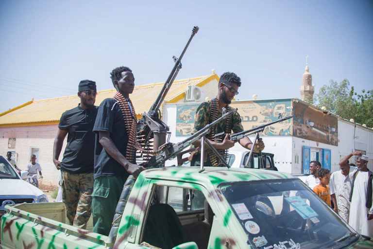 Men on the back of a truck with large guns.