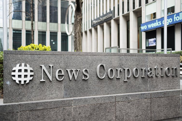 A rectangular grey sign reading News Corporation