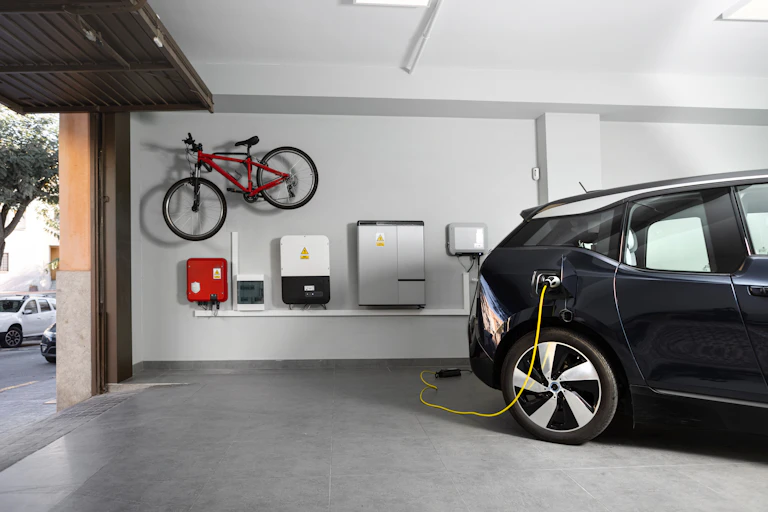 Home battery and EV charging station in a garage, with a bike stored on the wall