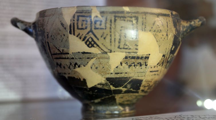 A greek cup with engravings and two small handles (circa 725BC).