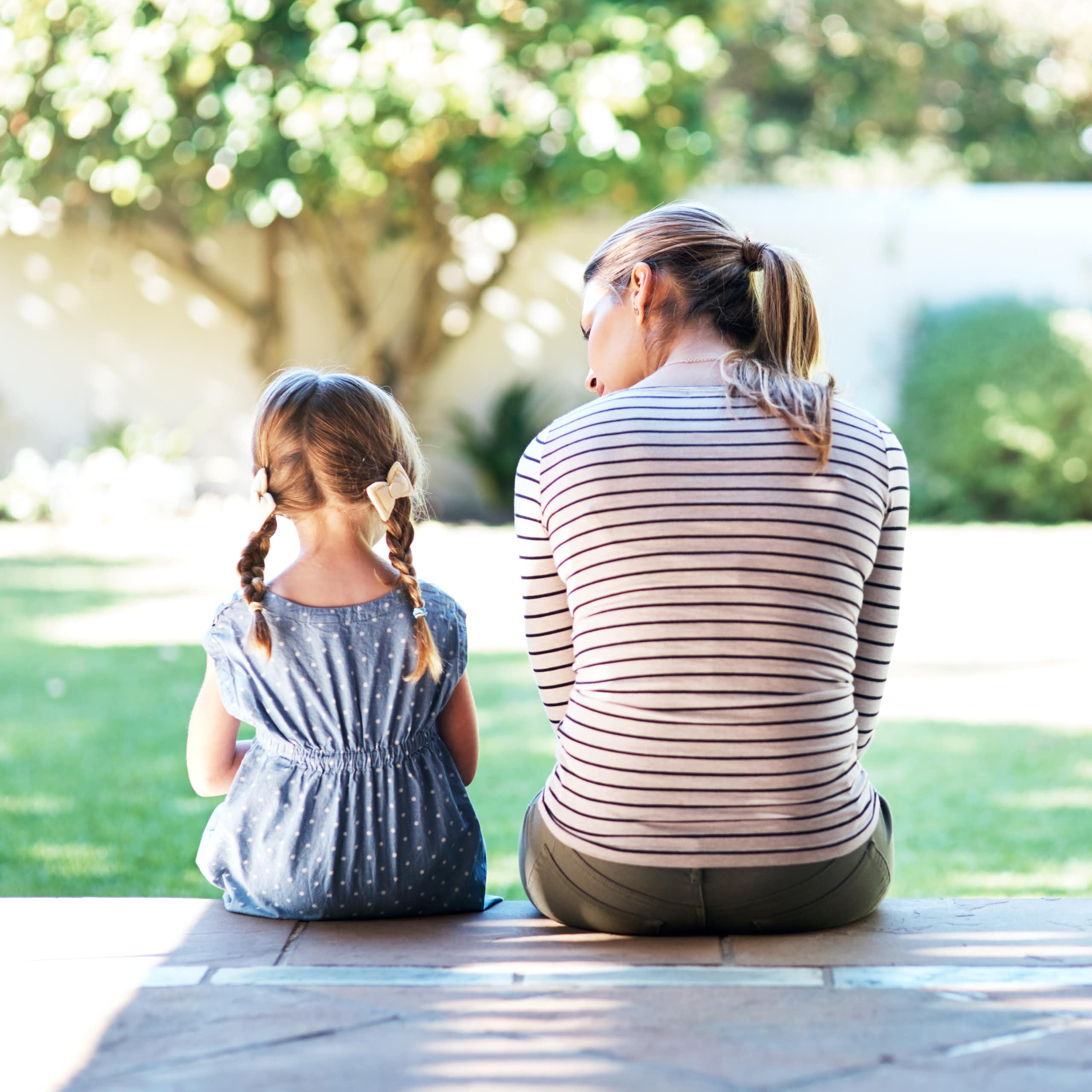 Rearview shot of a young woman and her daughter having a conversation on the porch.
