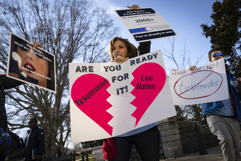 People protest holding signs denouncing Ticketmaster.