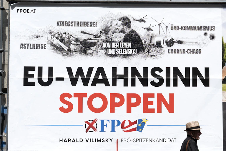 Un homme passe dans une rue de Vienne devant une affiche de campagne du FPÖ