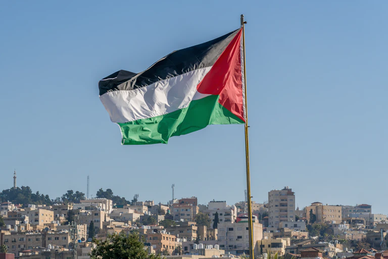 Palestinian flag flying above city horizon