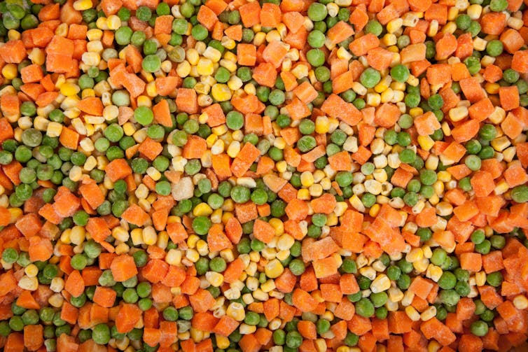 A close up of frozen vegetables (peas, carrot and corn).