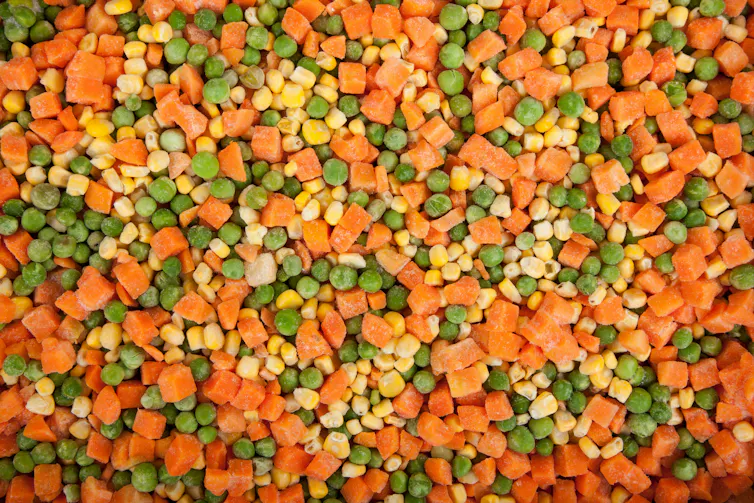 A close up of frozen vegetables (peas, carrot and corn).
