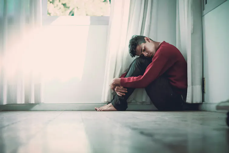 Man sits in corner