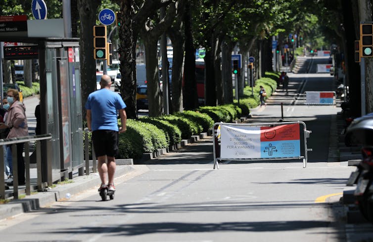 A man riding a scooter in a traffic-calmed lane.