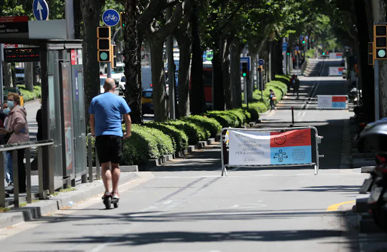 A man riding a scooter in a traffic-calmed lane.