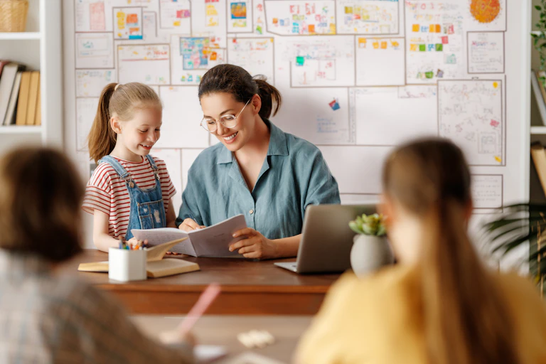 Happy student showing her work to her teacher