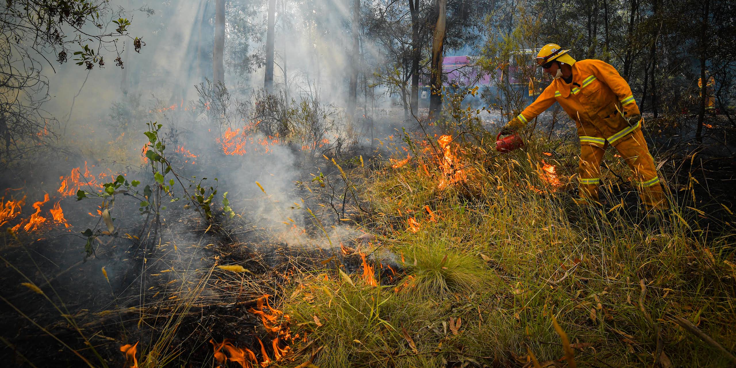 Person wearing hi-vis protective clothing while lighting a cool burn west of Corryong, Victoria.