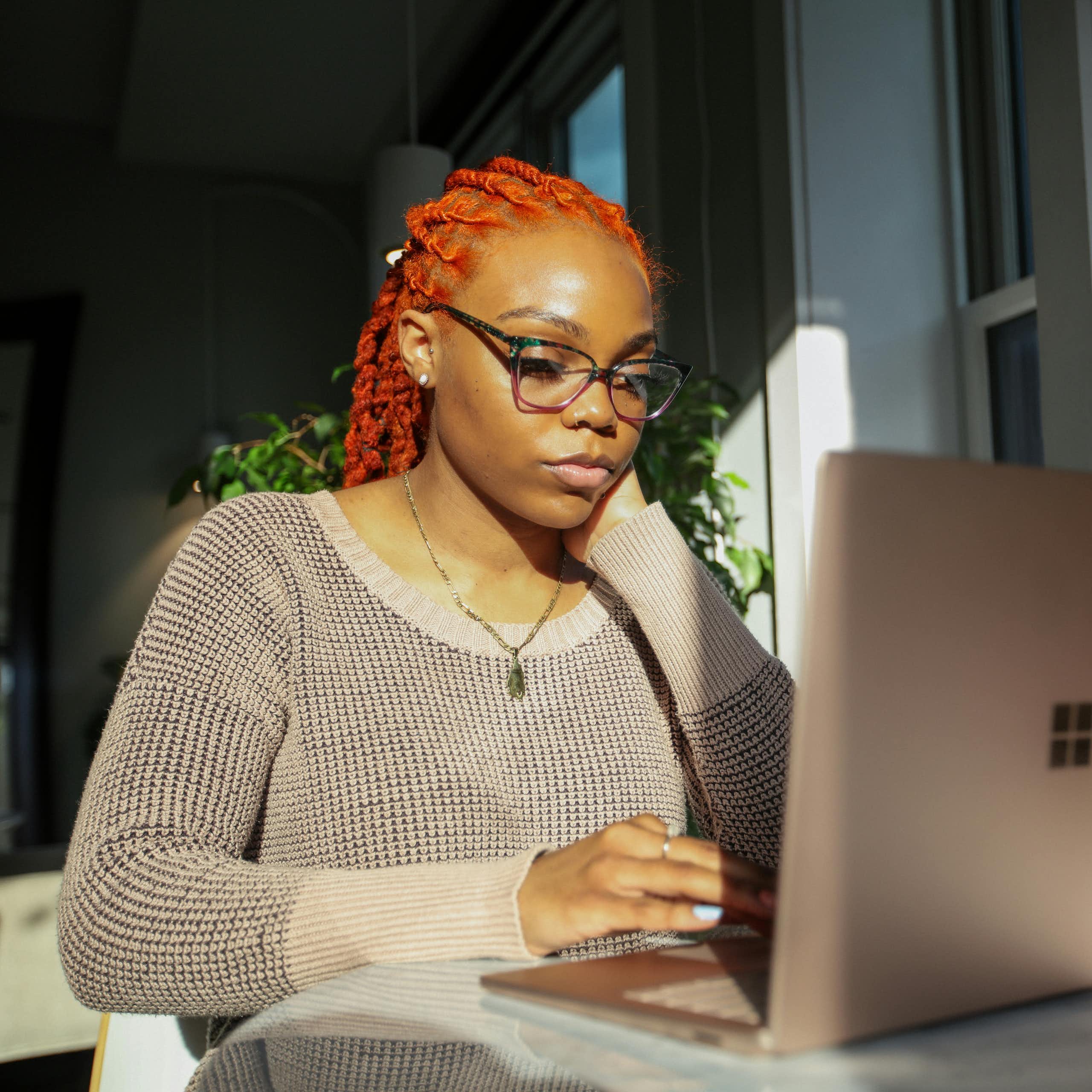 African-Australian woman types on laptop