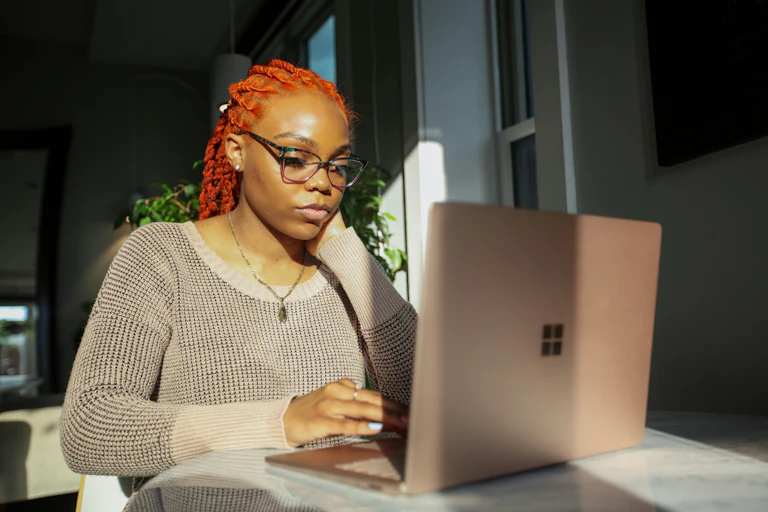African-Australian woman types on laptop