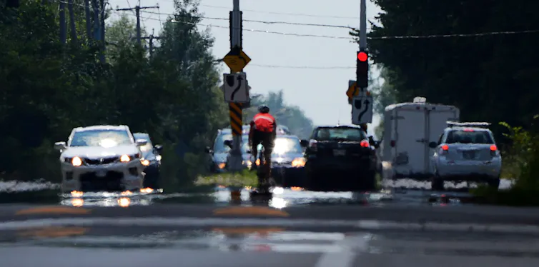 Cars and a cyclist at an intersection with heat haze