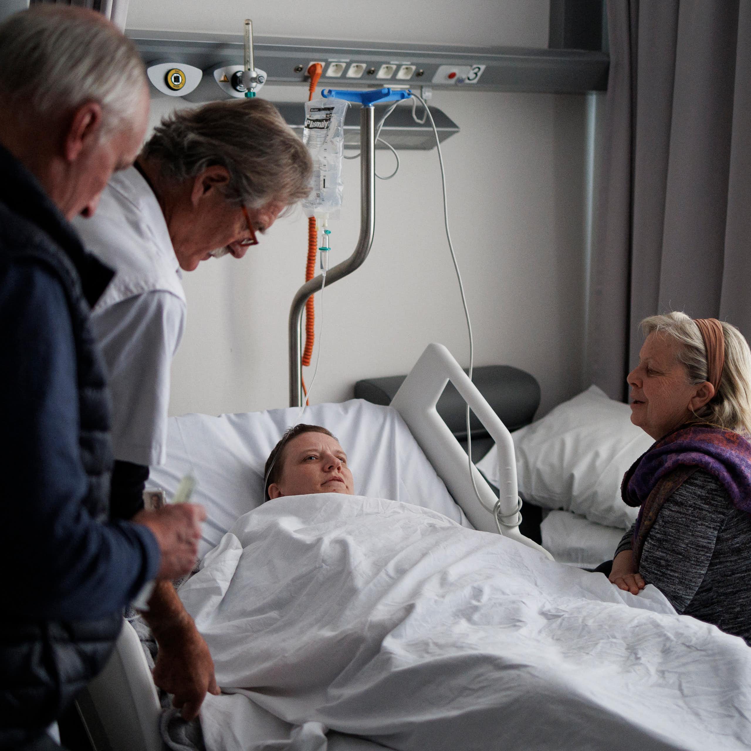  Le docteur Yves de Locht (L) et Wim Distelmans, professeur en soins palliatifs, arrivent dans la chambre d'hôpital pour l'euthanasie de Lydie Imhoff (C) tandis que son accompagnatrice Marie-Josée Rousseaux (D) lui tient la main dans un hôpital en Belgique, le 1er février 2024.