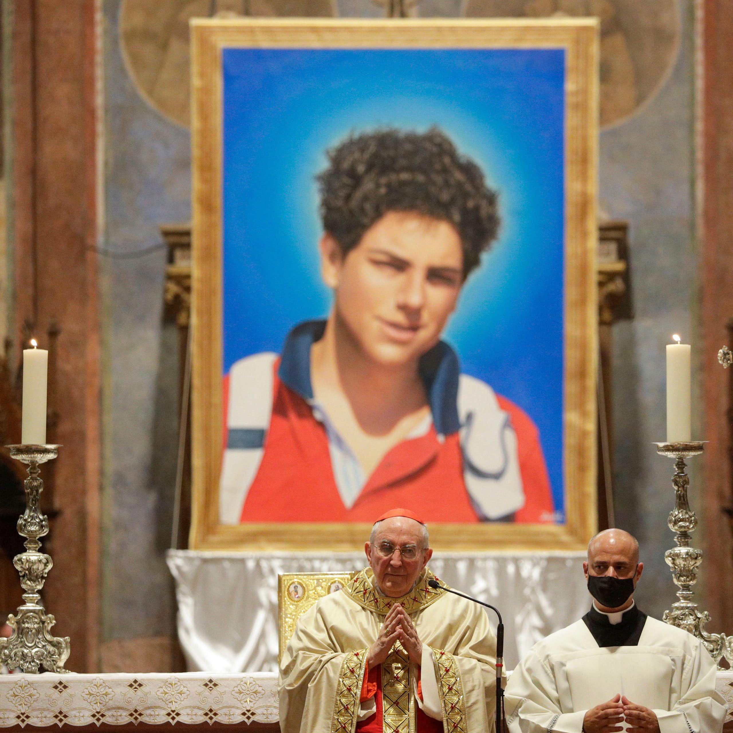 The Pope in front of an altar with a huge picture of Carlo Acutis on it.