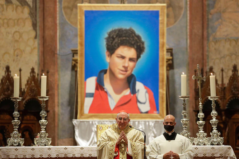 The Pope in front of an altar with a huge picture of Carlo Acutis on it.