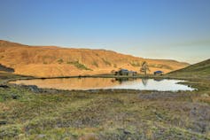 Two small houses near a lake in the Drakensberg