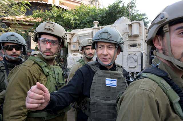 Israeli prime minister Benjamin Netanyahu dressed in combat gear with aides.