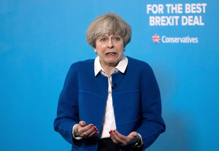Theresa May grimacing at a campaign event.