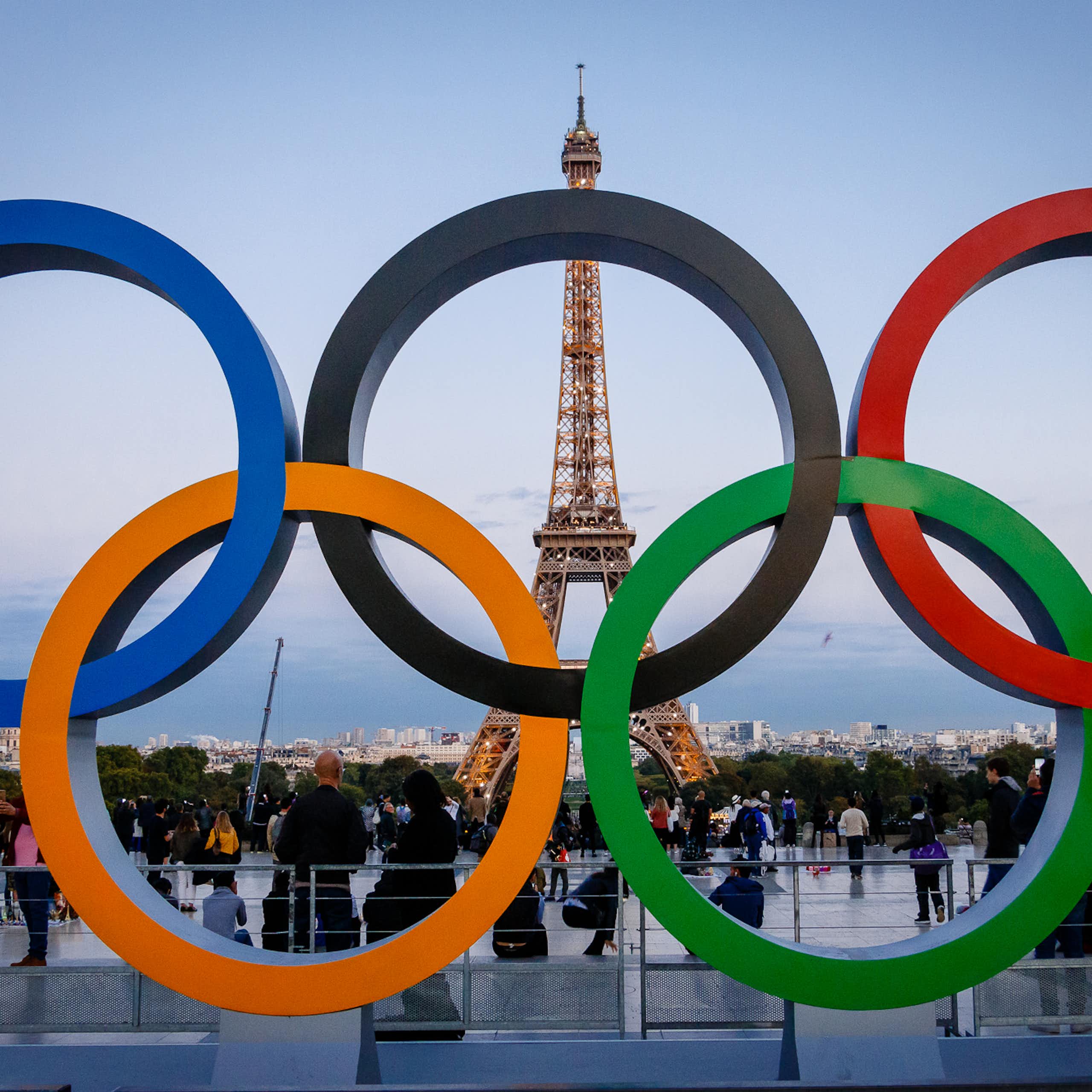 Five Olympic rings with the Eiffel Tower in the background.