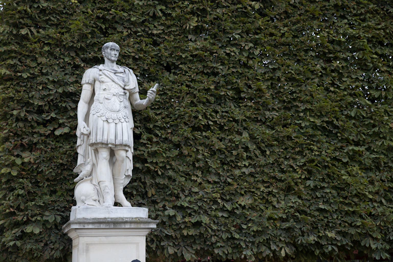 A statue of a man in classical armor atop a stone plinth.