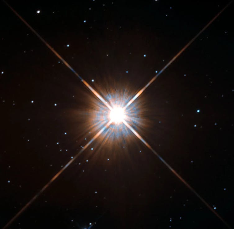 A bright burst against a dark field speckled with smaller stars