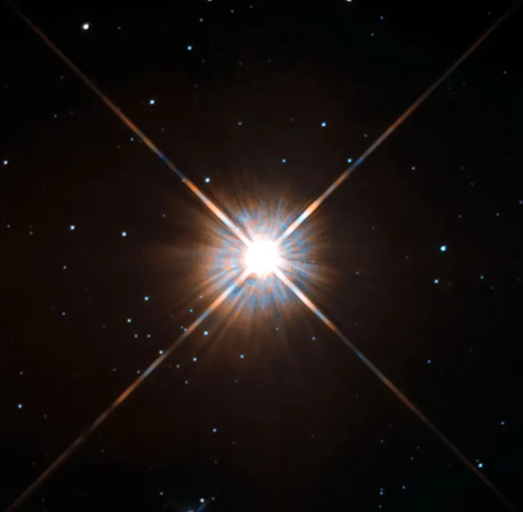 A bright burst against a dark field speckled with smaller stars