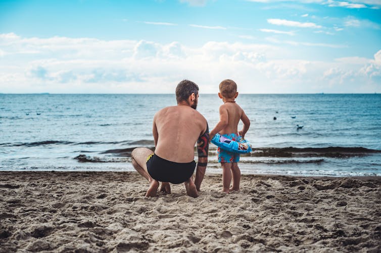 Dad talks to son at the beach