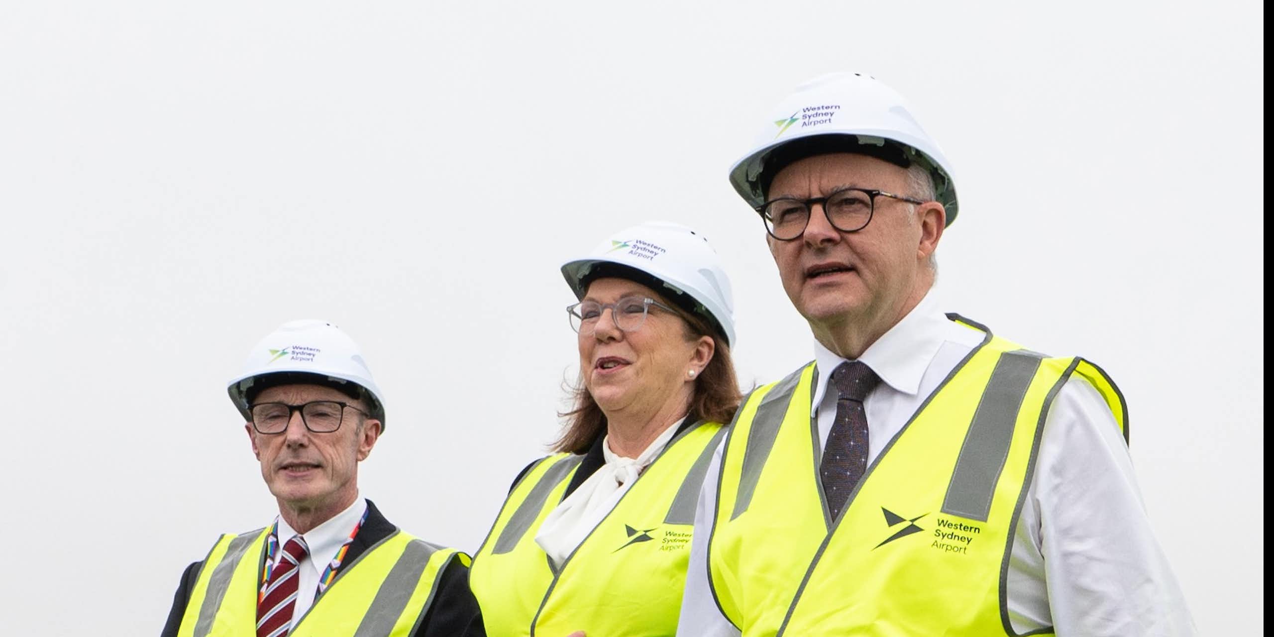 Minister Catherine King (centre) and Prime Minister Anthony Albanese (right) wear hardhats and hi-viz vests at an infrastructure announcement