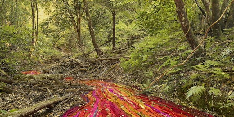 A red river of fabric in the forest.