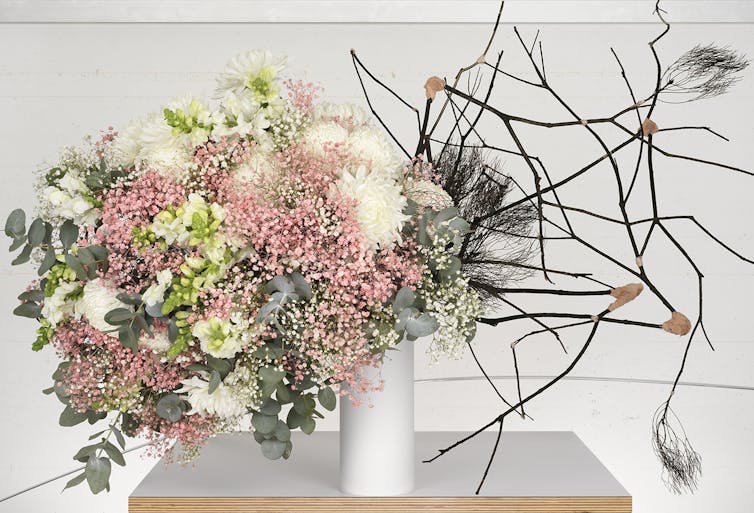 A vase with flowers and twigs.