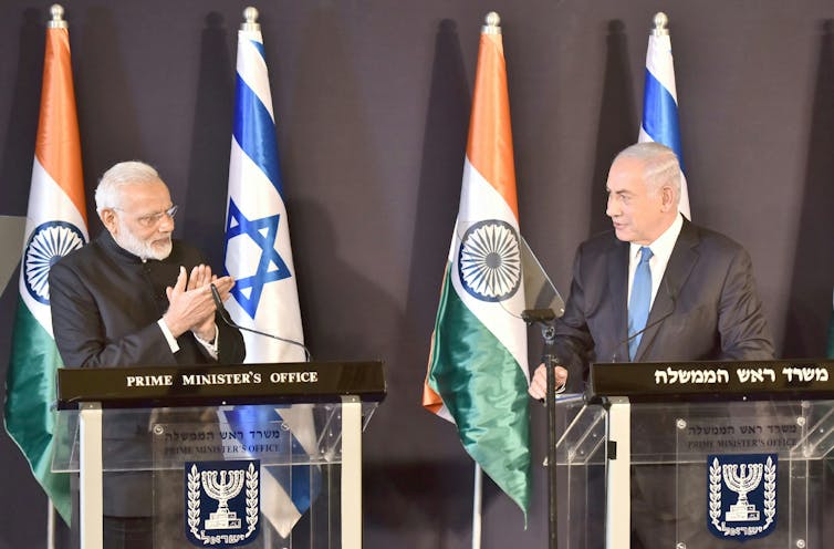 India: why Hindu nationalism and Zionism are ideological cousins 2 Narendra Modi and Benjamin Netanyahu facing each other on a stage in front of Indian and Israeli flags.
