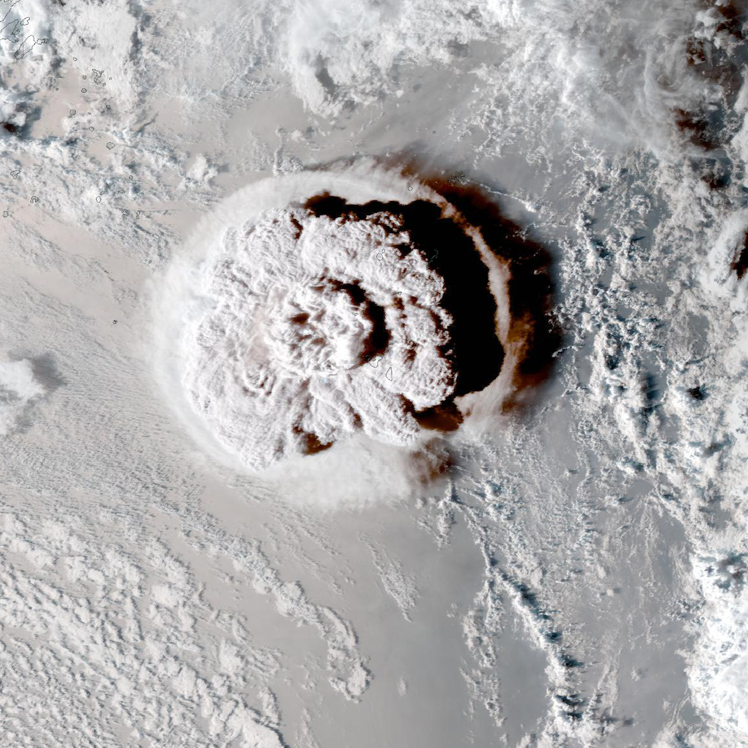 Satellite view of a grey ocean surface with cloud cover and a large plume emerging in the middle.