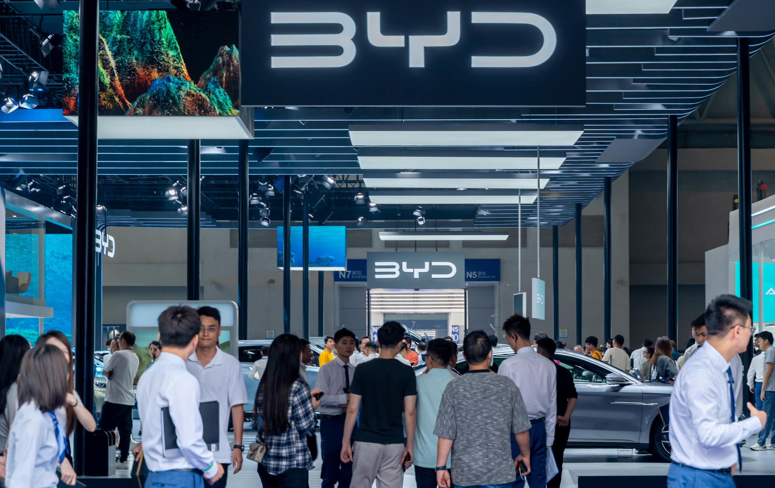 Des personnes déambulent sur le stand du constructeur chinois de véhicules électriques, Byd. 