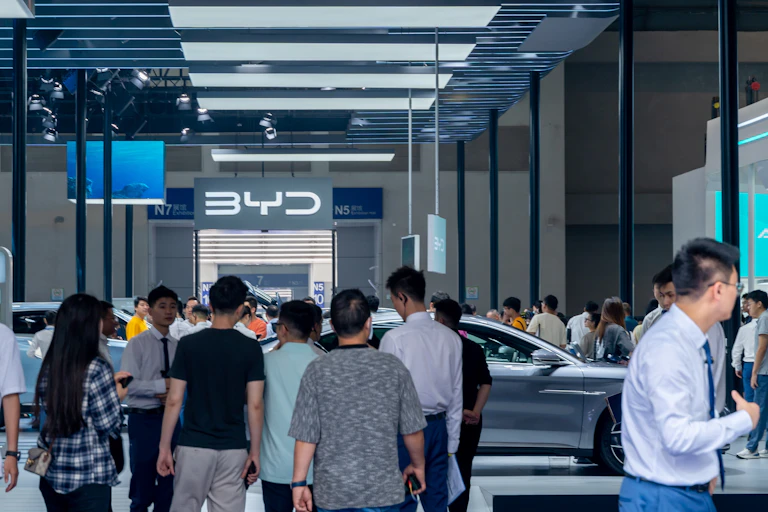 Des personnes déambulent sur le stand du constructeur chinois de véhicules électriques, Byd.
