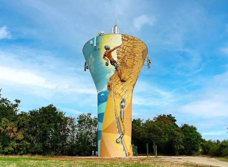 chateau d’eau peint avec une fresque dans un paysage